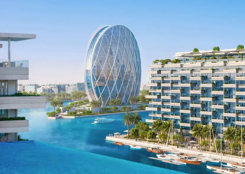 Terraced building and an oval glass tower across the marina lagoon