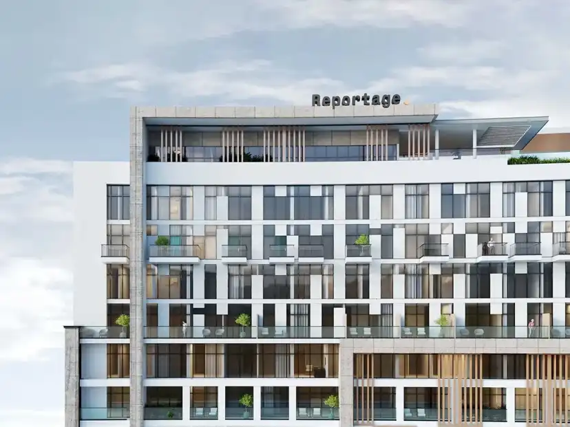 Facade of the building with balconies and a rooftop sign