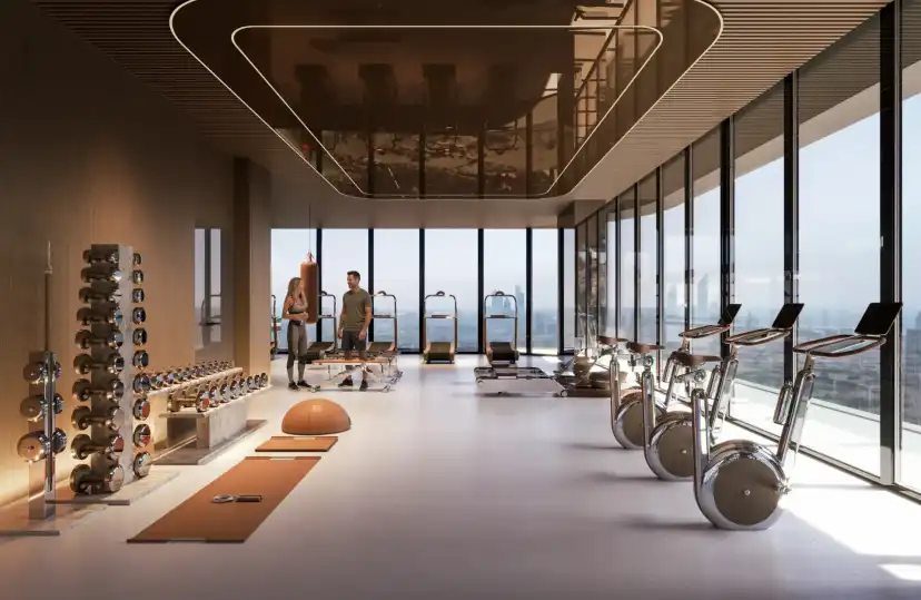 Gym with weights, cycling machines and floor to ceiling windows over the city