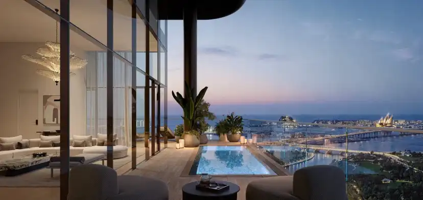 Terrace with a plunge pool and lounge seating at dusk overlooking the waterfront