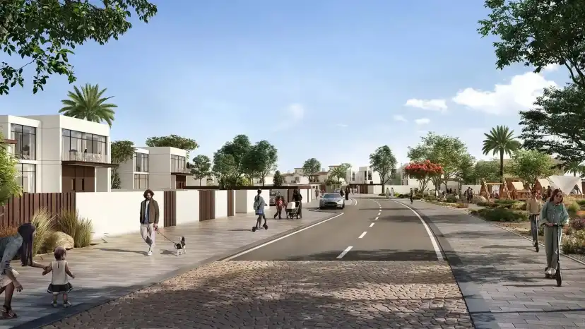 Village street with cyclists and white villas behind garden walls