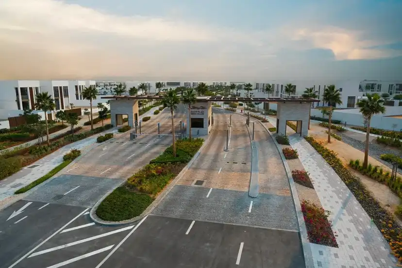 Entrance road to the community with a gateway and palm-lined verges