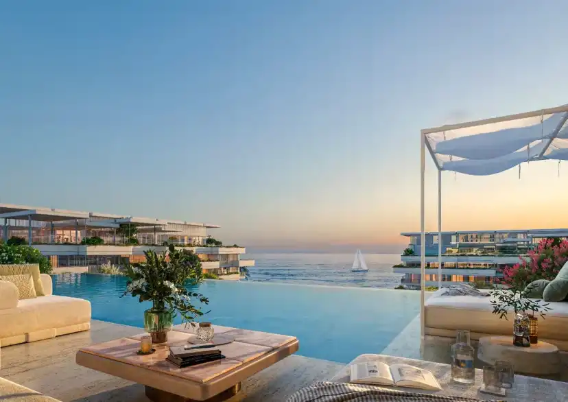 Infinity pool terrace with daybeds looking over the sea at sunset