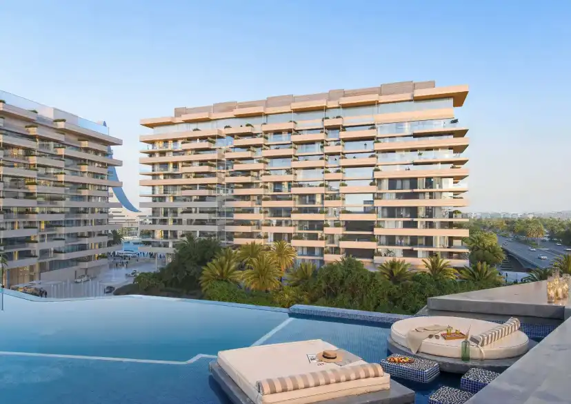 Infinity pool with daybeds in front of the residential building
