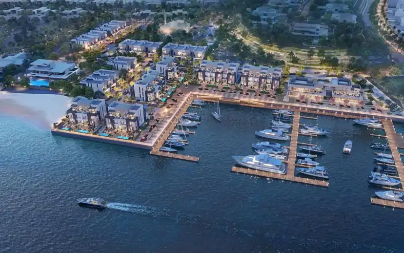 Aerial view of the marina at dusk with lit buildings along the quay