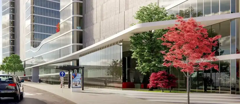 Glazed ground floor entrance of the towers with a red maple tree