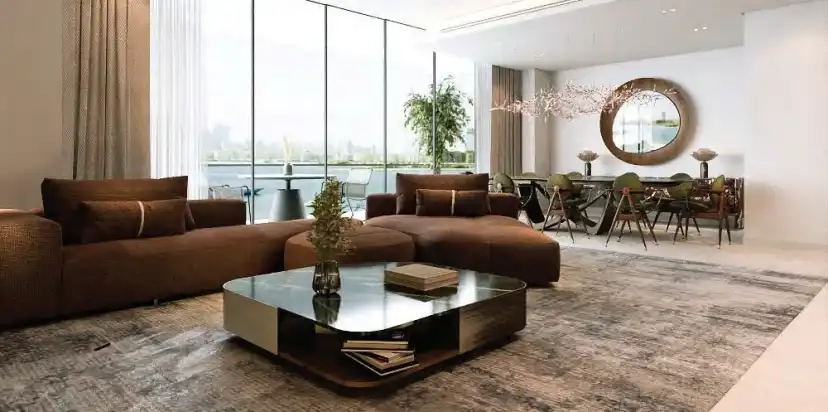 Living and dining area with brown sofas and large windows over the waterfront
