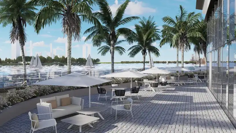 Waterfront terrace with seating and umbrellas beside the palm trees