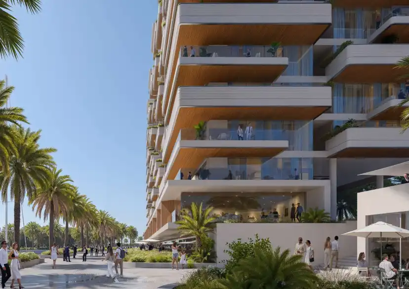 Building balconies above a palm-lined waterfront promenade
