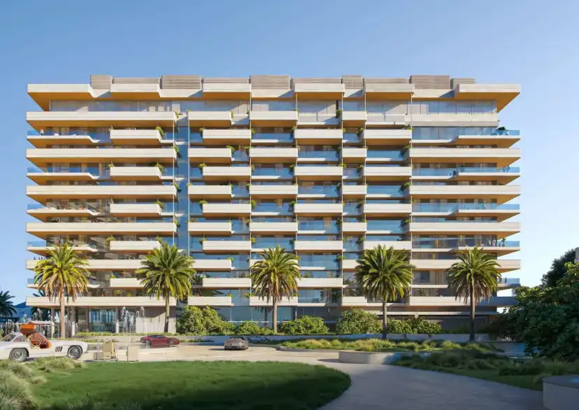 Residential building with gold and blue balconies behind a lawn and palm trees
