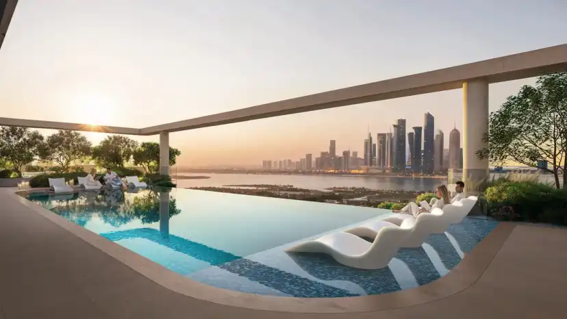 Pool deck with sun loungers and the Abu Dhabi skyline at sunset