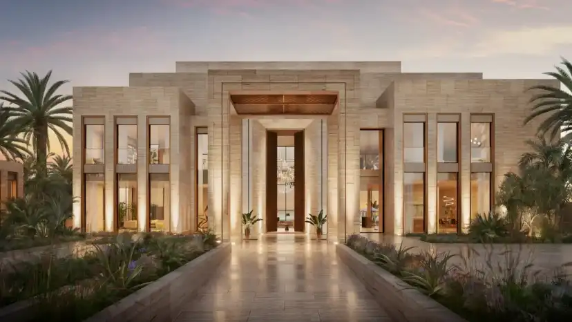 Stone mansion with a tall arched entrance hall lit at dusk