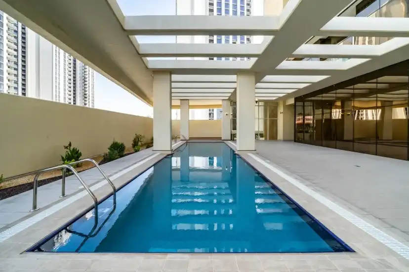 Indoor lap pool under a pergola with a glazed wall